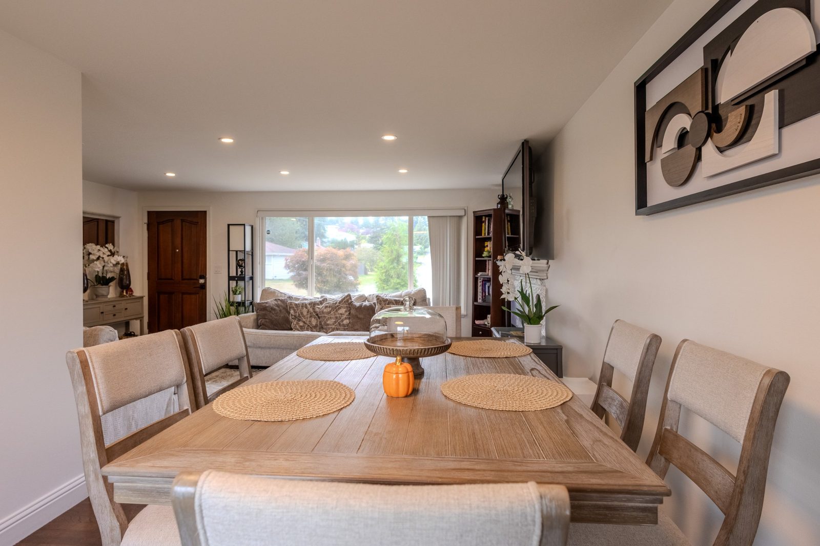 Dining table set for six, looking toward the living room and front window