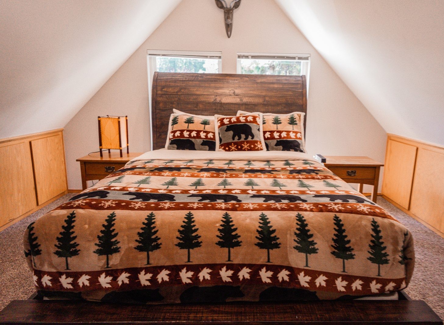 Loft primary bedroom under a vaulted ceiling with a wood sleigh bed